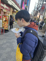 男性,食べ歩き,ホットドッグ,冬服,アーケード街,バックパック,街角,飲食店,黄色い袋