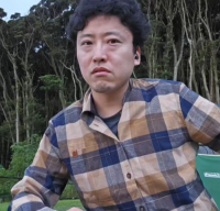 男性,屋外,チェックシャツ,木,短髪,座っている,真顔